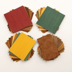 Colorful assortment of wood veneer sheets used for marquetry and wood inlay work, fanned out on a white background