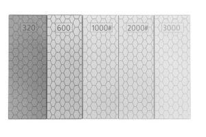 Set of diamond sharpening plates on a woodworking bench with a chisel being sharpened