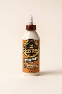 An 8-ounce bottle of Gorilla Wood Glue in natural wood color with a precision tip nozzle