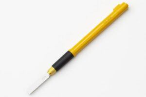 Close-up photo of the OLFA 167B hobby saw with a yellow handle, black rubber grip, and thin carbon-steel blade, displayed on a clean white background.