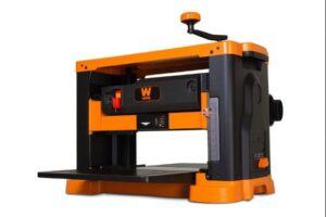 Benchtop thickness planer with orange and black housing shown on a white background, designed for smoothing and thicknessing wood boards.
